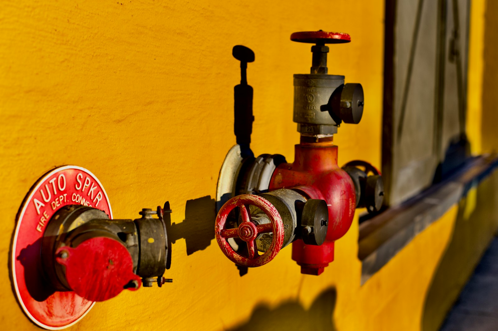Real fire protection valve and sprinkler connection mounted on a building wall